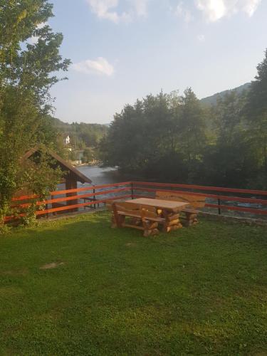 a picnic table in the grass next to a fence at Vinac guest house in Jajce