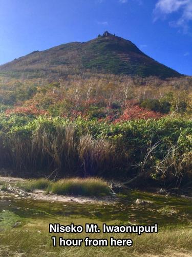 a mountain in the distance with the words nissko i at TOYA HOME kairou 一棟貸切 in Lake Toya