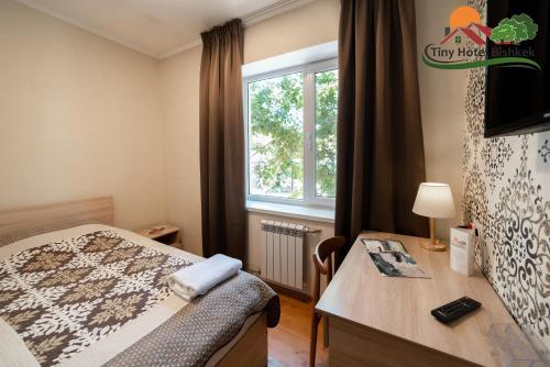 Un pat sau paturi într-o cameră la Tiny Hotel Bishkek