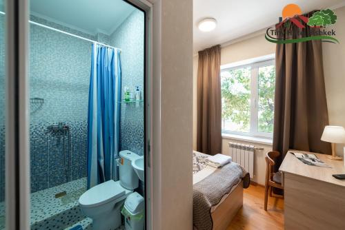 a bathroom with a shower and a toilet and a sink at Tiny Hotel Bishkek in Bishkek