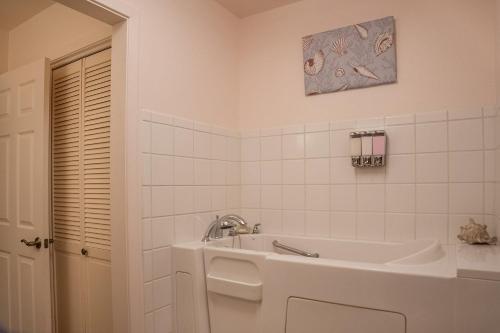 a white bathroom with a tub and a sink at Wine’D Up in Fredericksburg