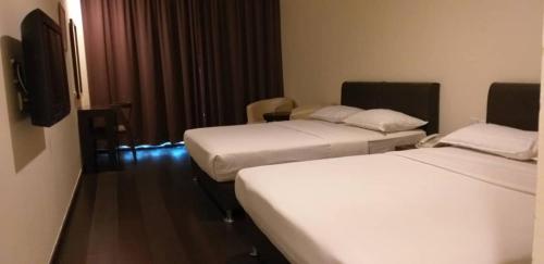 a hotel room with two beds and a television at Manja Hotel in Kota Kinabalu