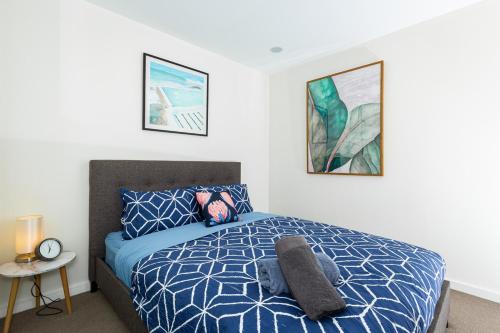 a bedroom with a bed and two pictures on the wall at Bond Quarter Loft in Melbourne