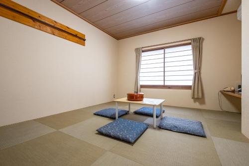 sala de estar con mesa y ventana en Kawaguchiko Station Inn, en Fujikawaguchiko