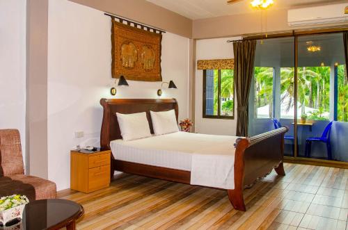 a bedroom with a bed and a living room at Allstar Guesthouse in Karon Beach