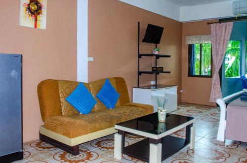 a living room with a couch and a table at Allstar Guesthouse in Karon Beach