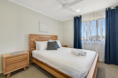 a bedroom with a large bed with blue curtains at CANAL HOME NEAR MOOLOOLABA - Kooringal in Buddina