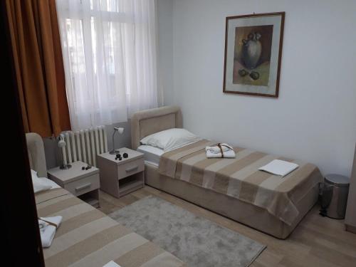 - une petite chambre avec 2 lits et une fenêtre dans l'établissement Apartman Karadjordje, à Zvezdara