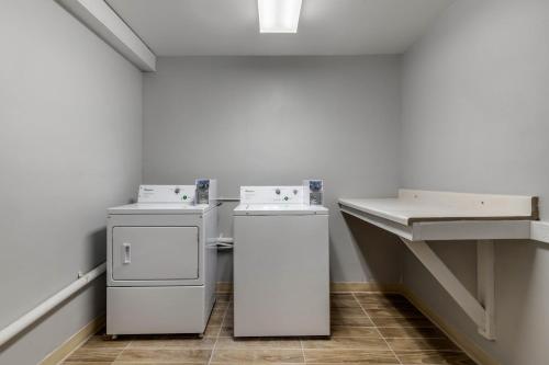 a laundry room with two machines and a sink at Day Inn by Wyndham San Antonio Downtown in San Antonio
