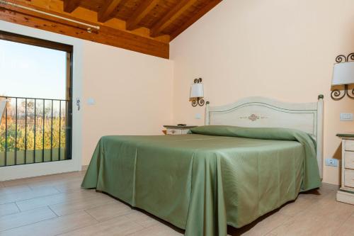 sypialnia z zielonym łóżkiem i oknem w obiekcie Agriturismo il Grappolo w mieście Lazise