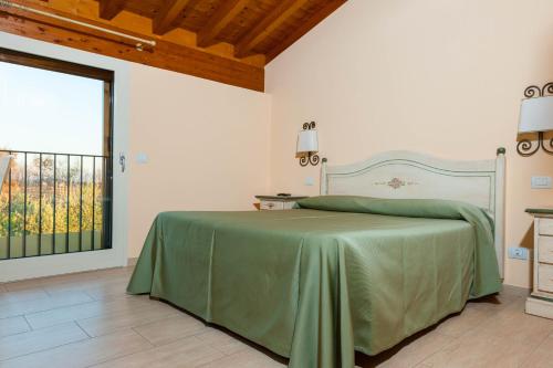 um quarto com uma cama verde e uma janela em Agriturismo il Grappolo em Lazise