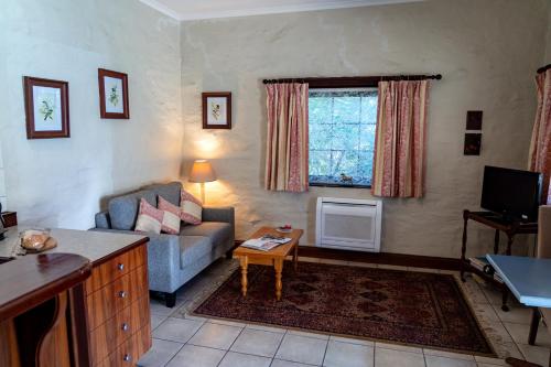 a living room with a couch and a table at Gasworks B&B Cottages in Strathalbyn