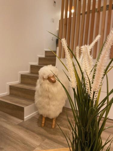 un animale di peluche è in piedi accanto a una scala di Le Mouton à 5 Pattes Aubagne-Cassis-Aix en Provence a Aubagne