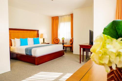 a bedroom with a bed and a desk and a television at Citi Park Hotel Cebu powered by Cocotel in Cebu City