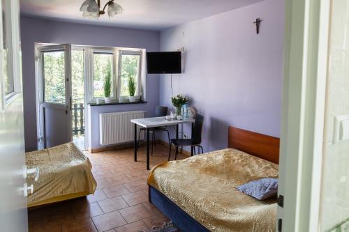 a bedroom with two beds and a table with a desk at Agroturystyka Krężniczanka in Lublin