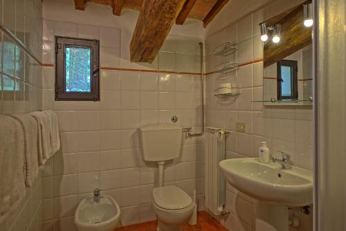 Un baño blanco con inodoro y lavabo. en Maggiano by PosarelliVillas, en Certaldo