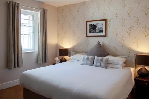 Un dormitorio con una gran cama blanca y una ventana en Three Salmons Hotel, en Usk
