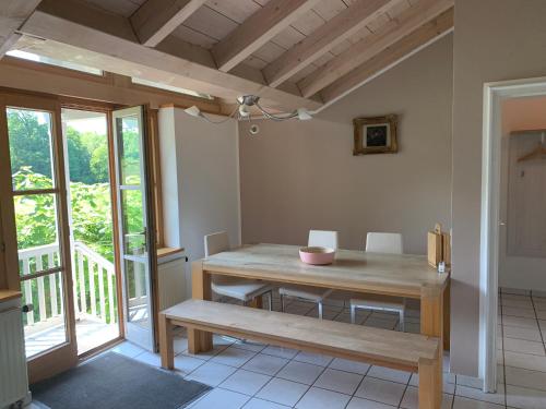 a dining room with a wooden table and a bench at Alpenblick Nahe München mit Outdoor Whirlpool - 21 Min von München mit Zug in Aßling