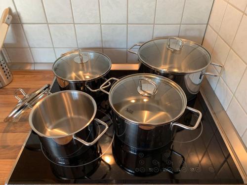 four pots sitting on a stove in a kitchen at Alpenblick Nahe München mit Outdoor Whirlpool - 21 Min von München mit Zug in Aßling