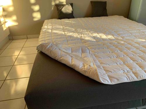 a bed with a white comforter on top of it at Alpenblick Nahe München mit Outdoor Whirlpool - 21 Min von München mit Zug in Aßling