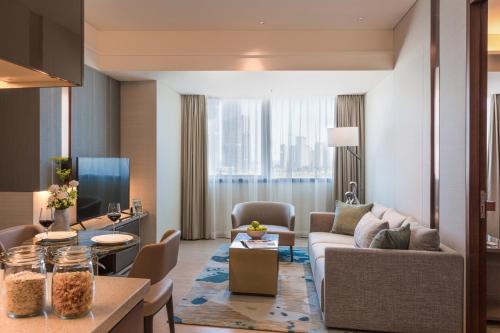 a living room with a couch and a table at Fraser Suites Dalian in Dalian