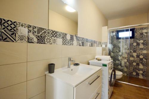 a white bathroom with a sink and a toilet at Mandarin Premium Apartments in Târgu-Mureş