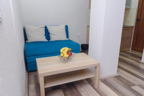 a blue couch and a table with bananas on it at City Center Studio in Strumica