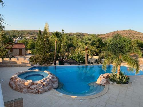 a large swimming pool with a large rock around it at Rancho Relaxo - "A Luxurious Hideaway for Couples and Honeymooners" in Nicosia