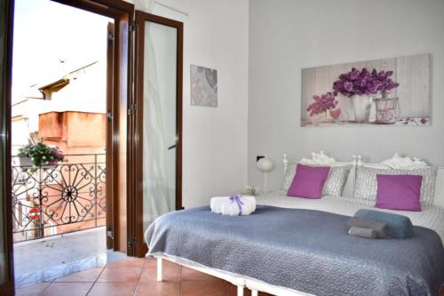 a bedroom with a large bed with purple pillows at Alma Nua in Terrasini