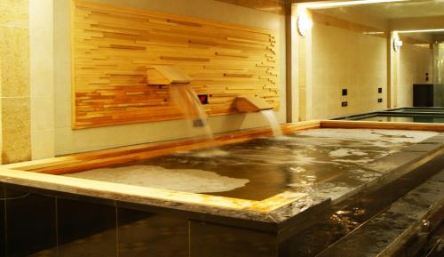 a hot tub in a room with a water fountain at Hotel Riviera Geoje in Geoje 