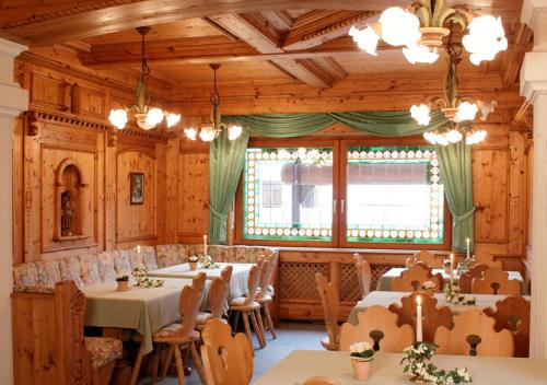 ein Restaurant mit Tischen und Stühlen und einem großen Fenster in der Unterkunft Gästehaus Cordula in Nistertal