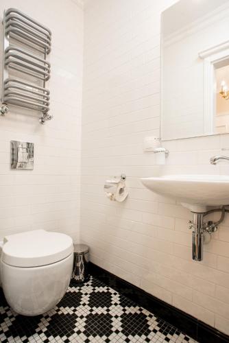 a white bathroom with a toilet and a sink at Willa Krakowska in Raszyn