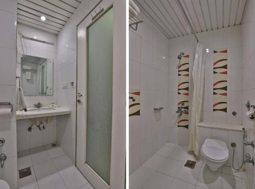 a bathroom with a shower and a toilet and a sink at HOTEL HARMONY in Vadodara