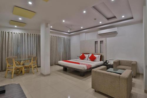 a bedroom with a bed and a table and chairs at HOTEL HARMONY in Vadodara