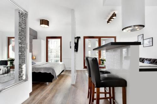 a kitchen and living room with a bed and a table at Elite Apartments Luna Spa&Welness in Gdańsk