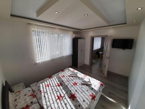 a bedroom with a bed with a quilt on it at Д и В 2 - D & V 2 Apartment in Sandanski