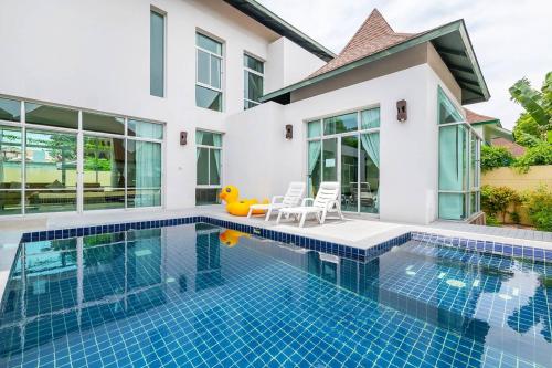 a swimming pool in the backyard of a house at AnB-Glass House pool villa-3BR close to Jomtien beach in Na Jomtien