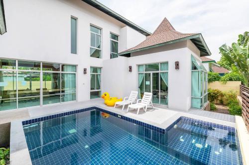 a villa with a swimming pool and a house at AnB-Glass House pool villa-3BR close to Jomtien beach in Na Jomtien