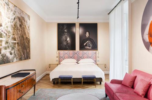 une chambre avec un lit et un canapé rouge dans l'établissement Galleria Vik Milano - Townhouse Galleria - Small Luxury Hotels of the World, à Milan