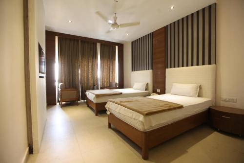 a hotel room with two beds and a window at Hotel Landmark in Chandīgarh