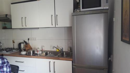 a kitchen with white cabinets and a sink and a microwave at Room in An Old House in Truskavets