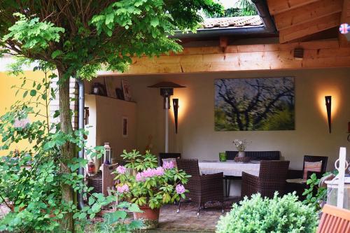 a patio with a table and chairs and flowers at Biggi‘s Bed&Breakfast in Flonheim