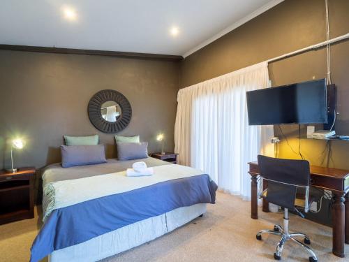 een slaapkamer met een bed, een bureau en een computer bij Private Studio flatlet, Uncapped Wifi, Netflix,Full DSTV in Durban