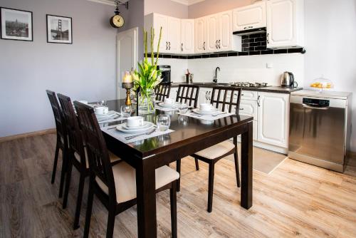 a kitchen with a black dining table and chairs at Willa Krakowska in Raszyn