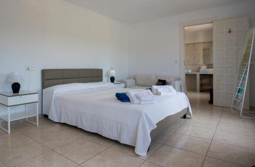 a white bedroom with two beds and a bathroom at Casa Stella in Jávea