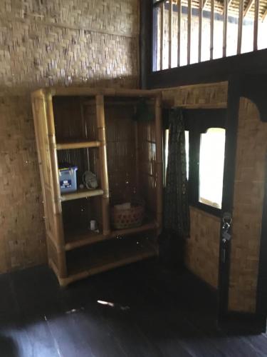 a room with a book shelf and a window at Good Karma Bungalows in Amed