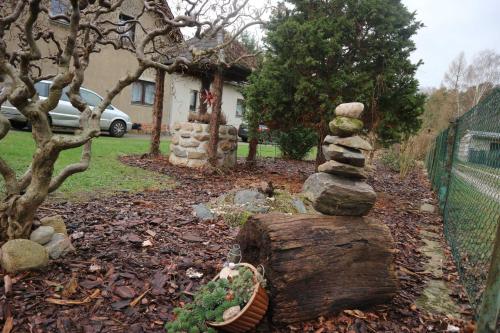 a stack of rocks sitting on top of a tree stump at Big Mama_s Home in Tschernitz