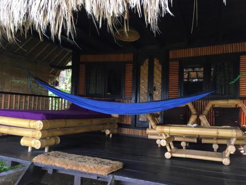 a hammock on the porch of a house at Good Karma Bungalows in Amed