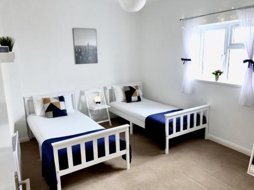 - une chambre avec 2 lits et une fenêtre dans l'établissement Eastbourne Beach Pier Apartment, à Eastbourne