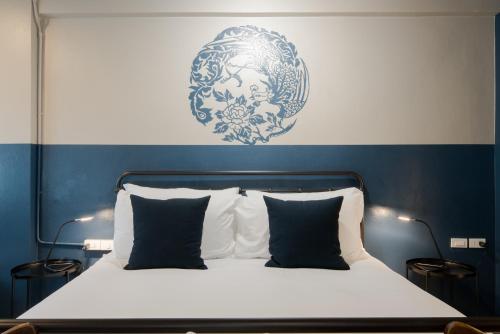 a bedroom with a bed with a blue and white wall at Blu Monkey Boutique Phuket Town in Phuket Town